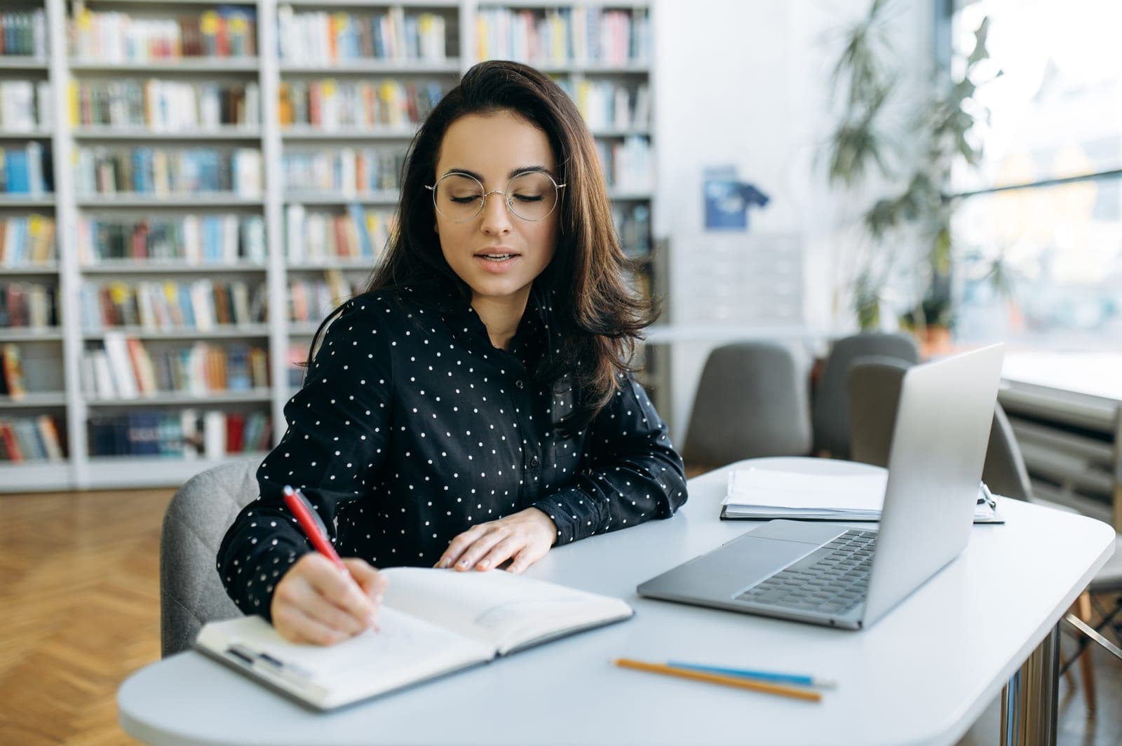 BCBA clinician conducting an RBT competency assessment with a young candidate at a therapy table using structured materials in a bright clinical setting